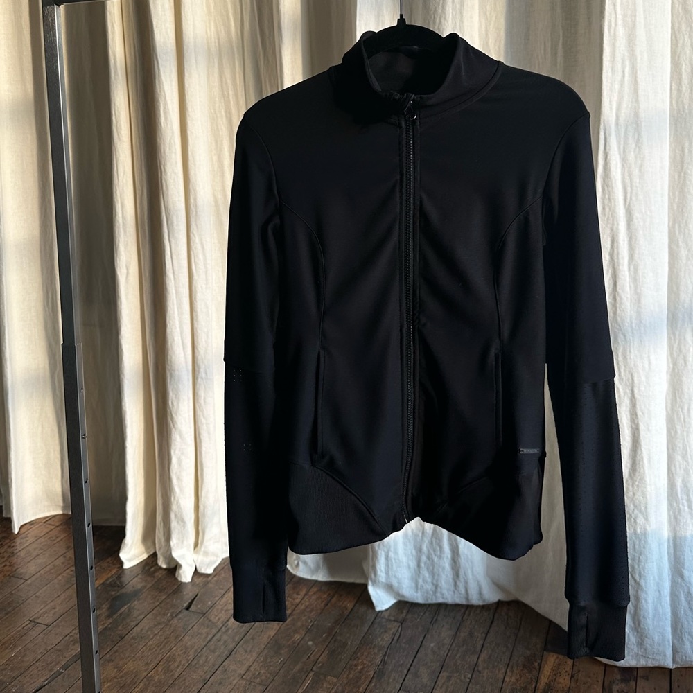 Black stretchy long sleeve workout jacket with mesh panels center front pockets